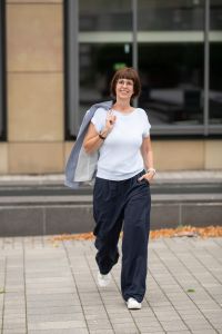 Monika Biewer geht auf mich zu; Blazer locker über der Schulter